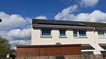 A house with solar panels on the roof AI-generated content may be incorrect.