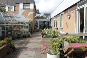 A courtyard with plants and a glass house